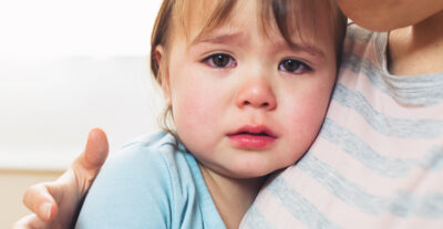 Crying toddler girl being consoled by her mother