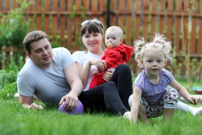 Family of four enjoying outdoors while sitting on the grass