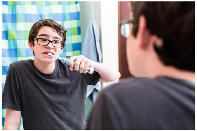 Boy standing in the bathroom brushing his teeth