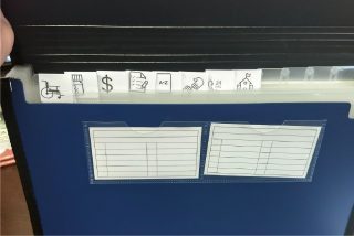 An open multi-fold binder is open with different tabs to be used in the care notebook
