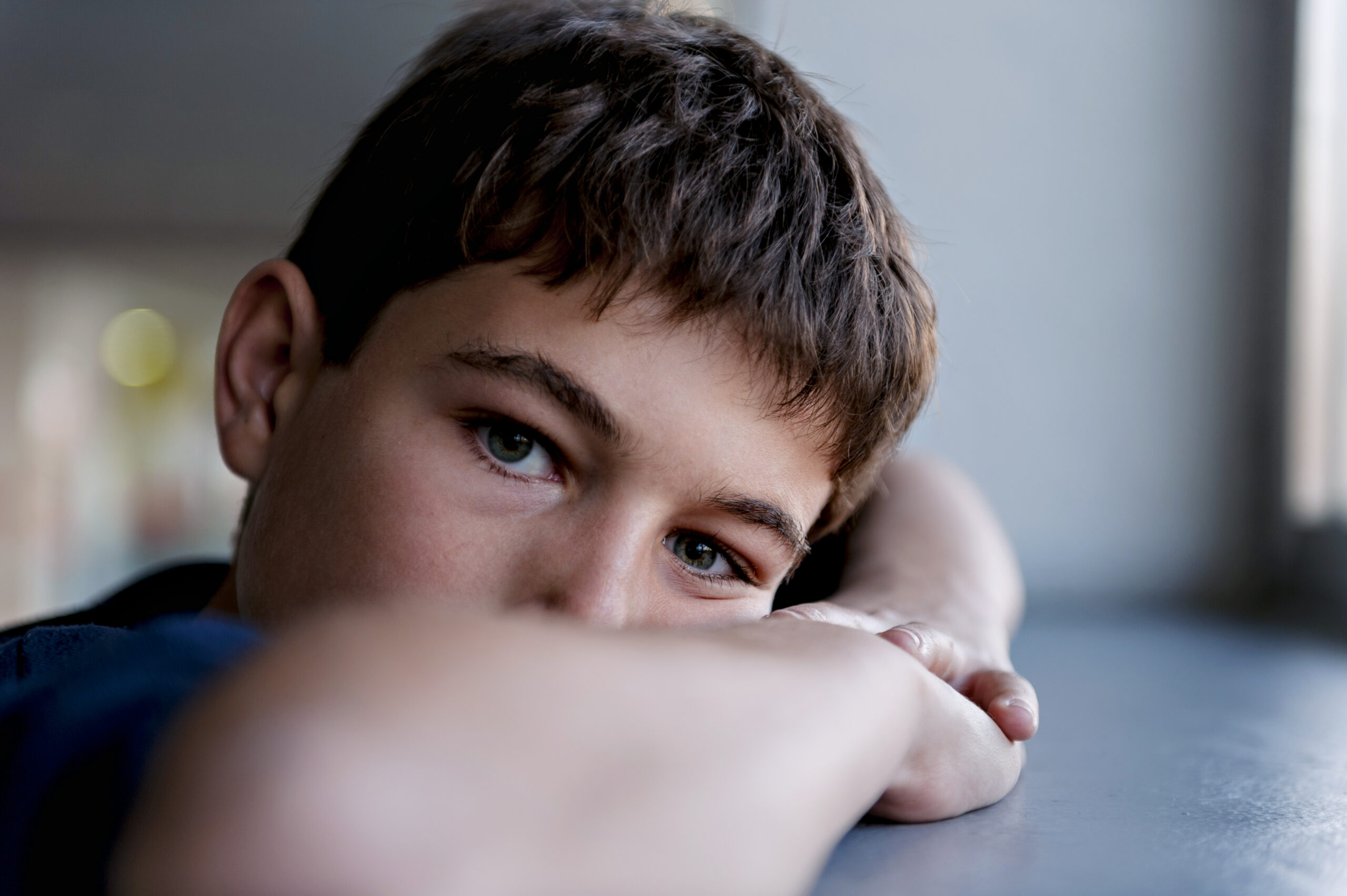 Pensive child looking through a window