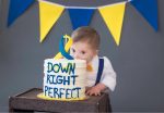 Child with down syndrome munches down on a cake titled down right perfect