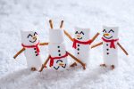 Happy funny marshmallow snowmen are having fun in snow