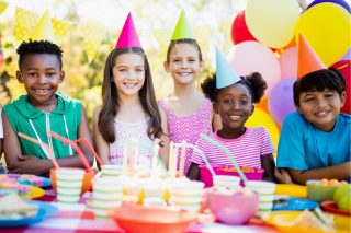 A group of Diverse children smile at a birthday party