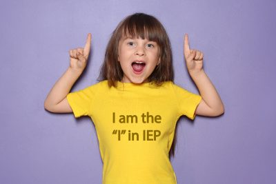 Little girl smiles and poses with the shirt that says I am the I in IEP