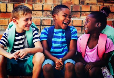 Kids in backpacks smiling