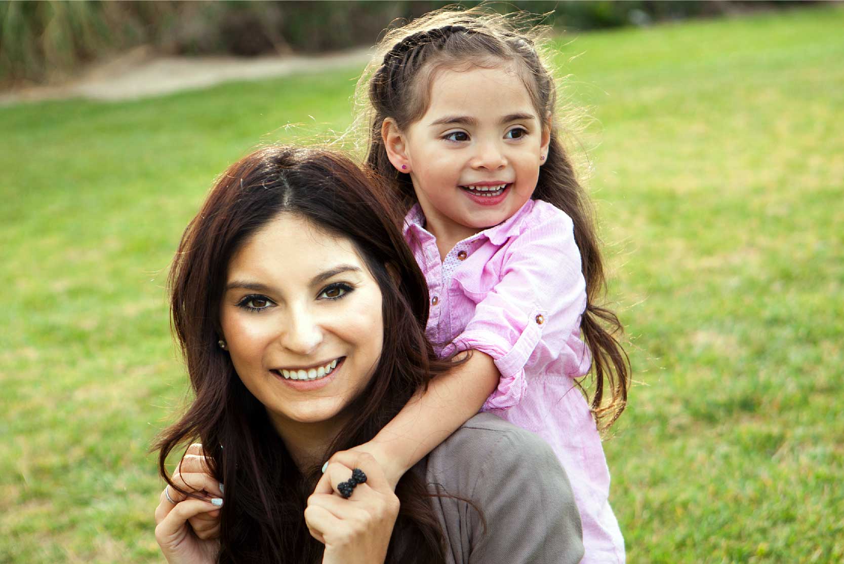 Mom smiles with little girl at the park
