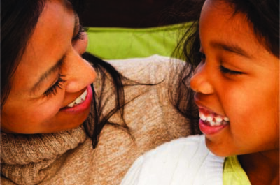 Diverse mom and daughter looking at each other and smiling