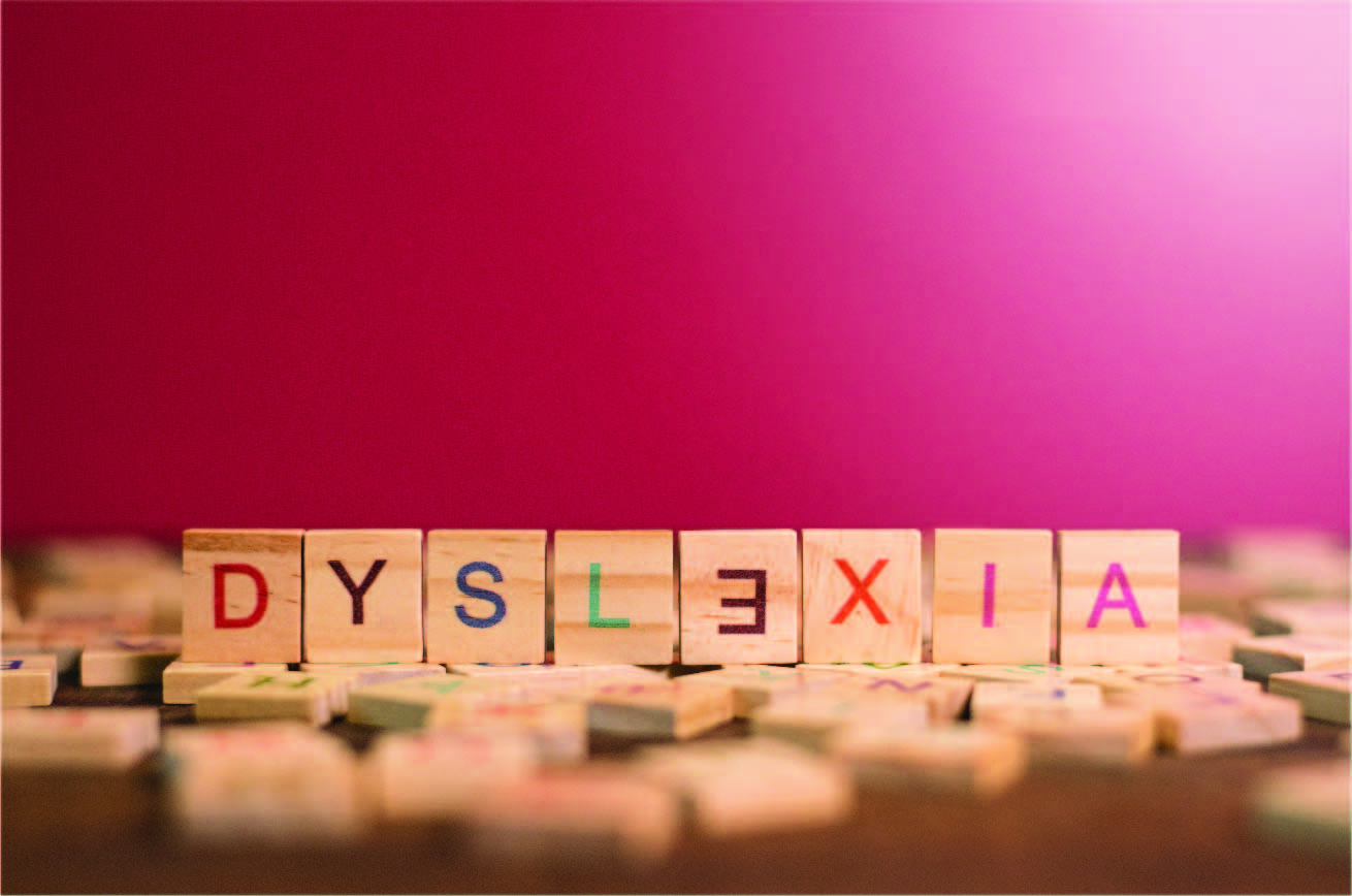 A pink background with word tiles spelling the word Dyslexia