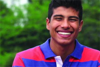 Teen boy smiles at a park