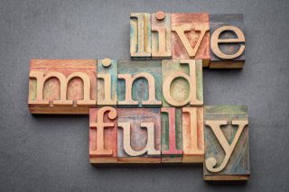 live mindfully - word abstract in letterpress wood type against gray slate stone