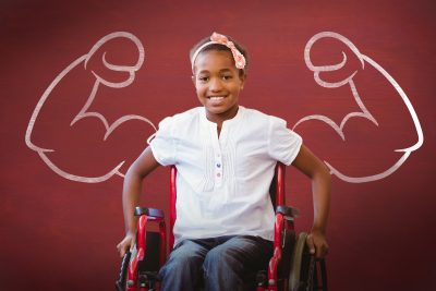 Girl sitting in wheelchair with a chalk drawing of muscles in the background