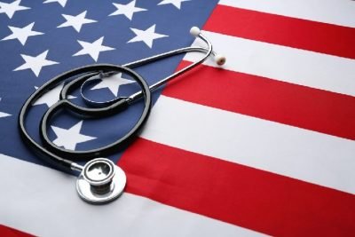 US flag laid flat with a stethoscope laying over it