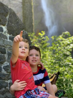 Two brothers school age observe and point at nature