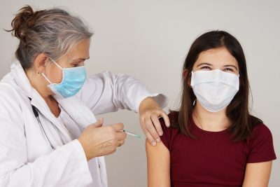 Teenager girl being vaccinated COVID concept