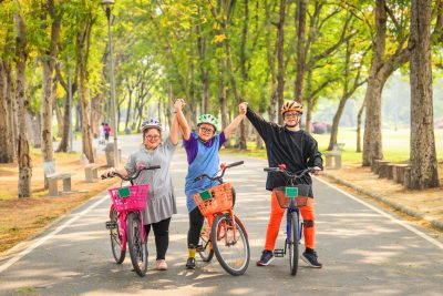 group of Asian friends with down syndrome or autism riding bicycle for exercise together outdoors in park