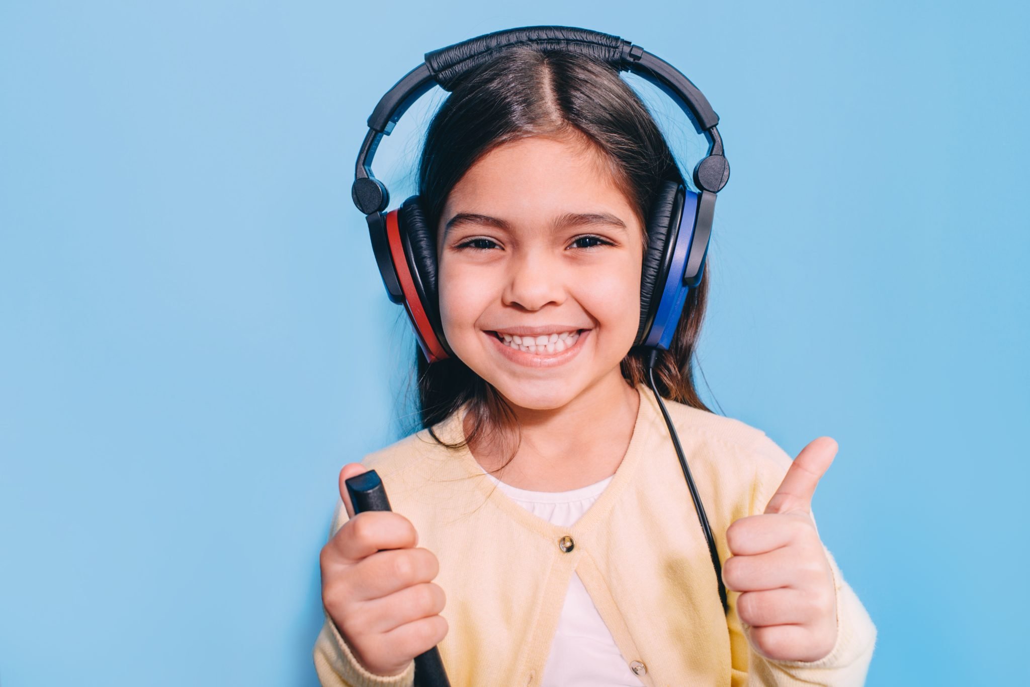 Cute little mixed race child while procedure hearing exam. Girl wearing special headphones getting hearing test, audiometry