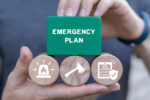 Man holding blocks with icons sees inscription: EMERGENCY PLAN. Business emergency plan concept. Checklist to do in disaster, continue business and build resilience concept. Smart emergency plan.