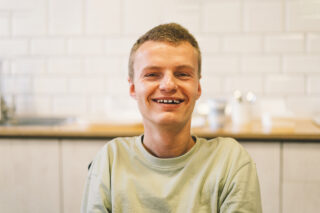 Portrait of young man with disabilities. Optimistic smiling
