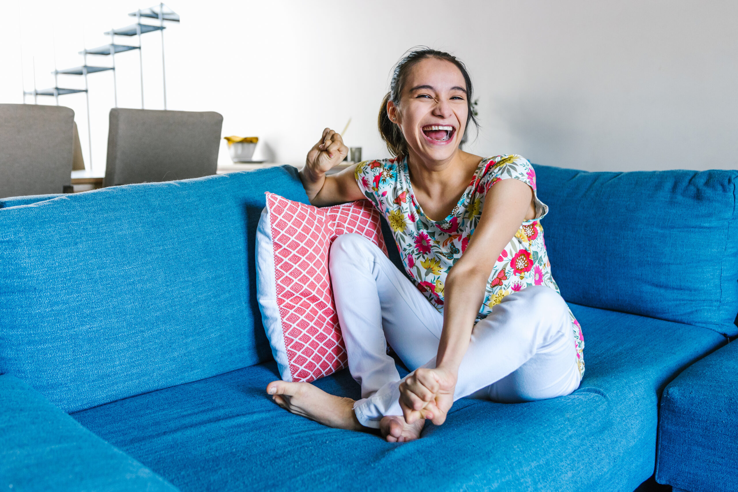 latin teen girl with cerebral palsy sitting on the couch relaxed and smiling