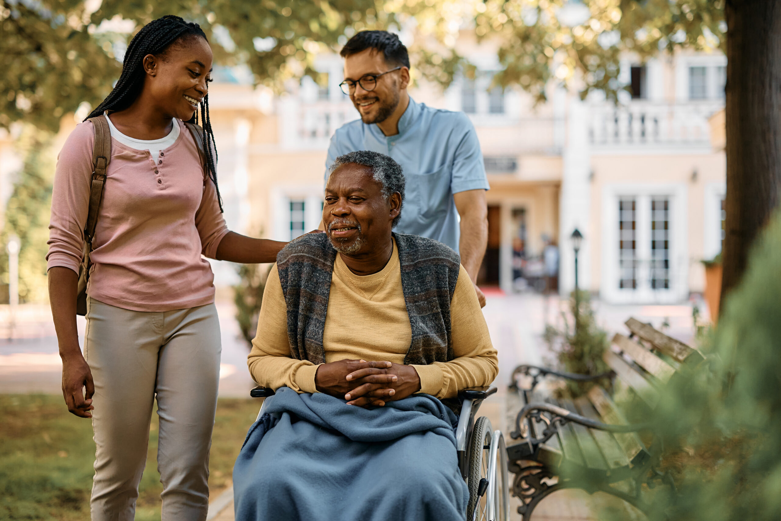 Happy black woman visiting her senior father in nursing home.