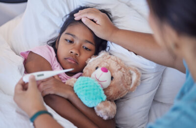 Sick thermometer, child health and mother reading fever, care for girl with covid and check on virus in bed of house. Kid resting with flu while mom takes temperature in bedroom of home with love.