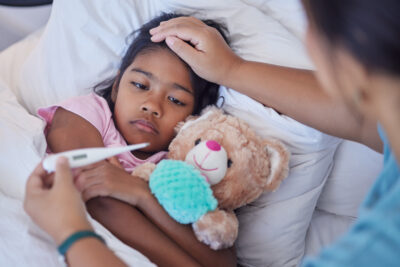 Sick thermometer, child health and mother reading fever, care for girl with covid and check on virus in bed of house. Kid resting with flu while mom takes temperature in bedroom of home with love.